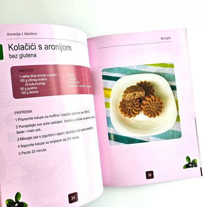 Aronija i Slastice (Aronia Desserts) Open cookbook showing a recipe for cookies with aronia berries on a white background