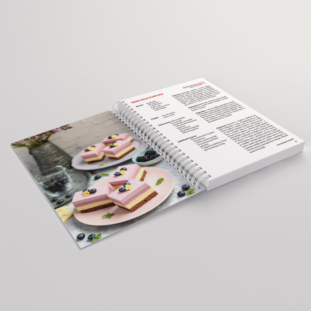 Moji Kremasti KOLAČI Open cookbook showing a recipe for heart-shaped desserts on a gray background