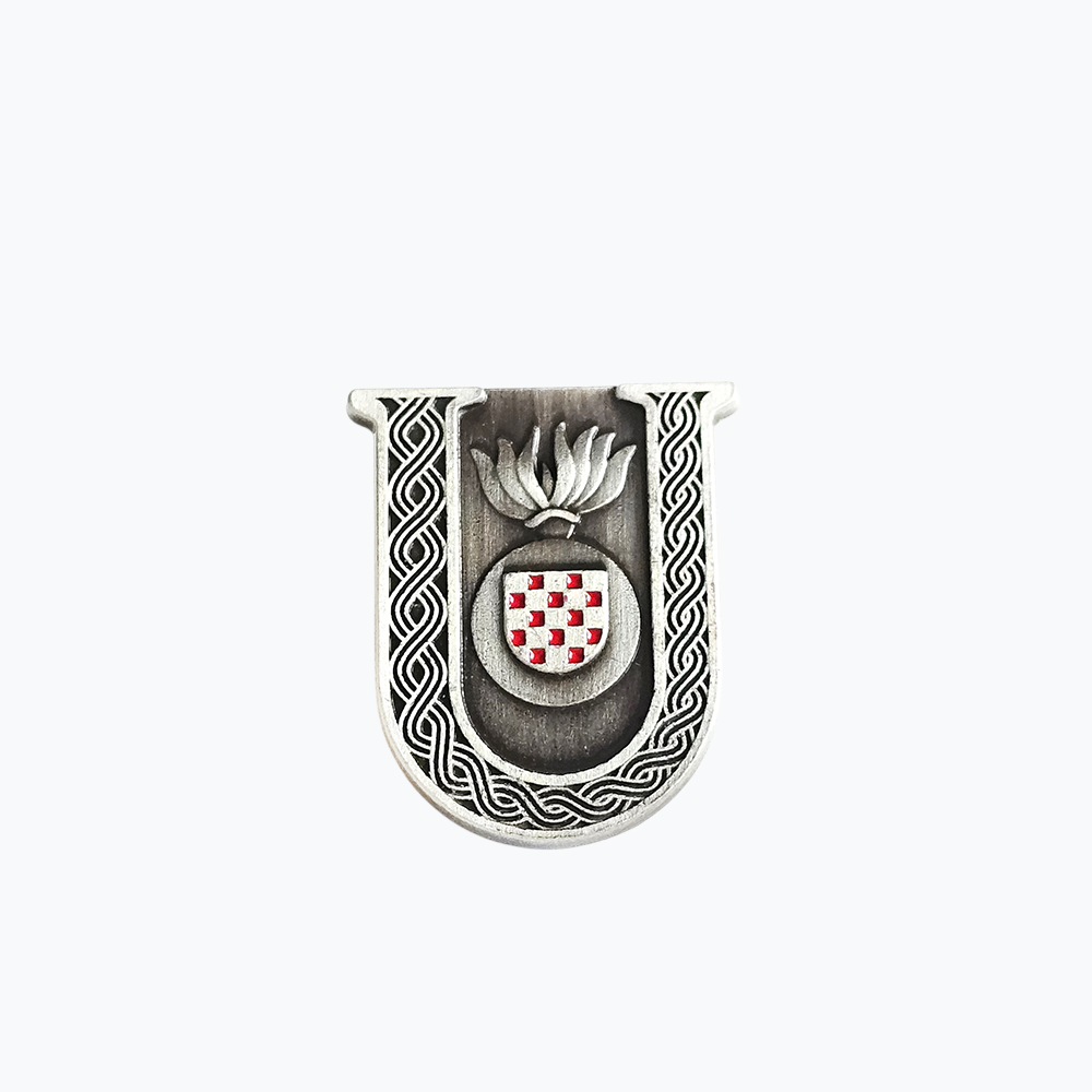 Pin Prvo Bijelo Polje U - Matte Silver Decorative metal item with a shield design and intricate border on a white background